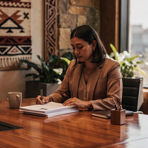 Administrator reviewing a printed set of meeting minutes at a desk